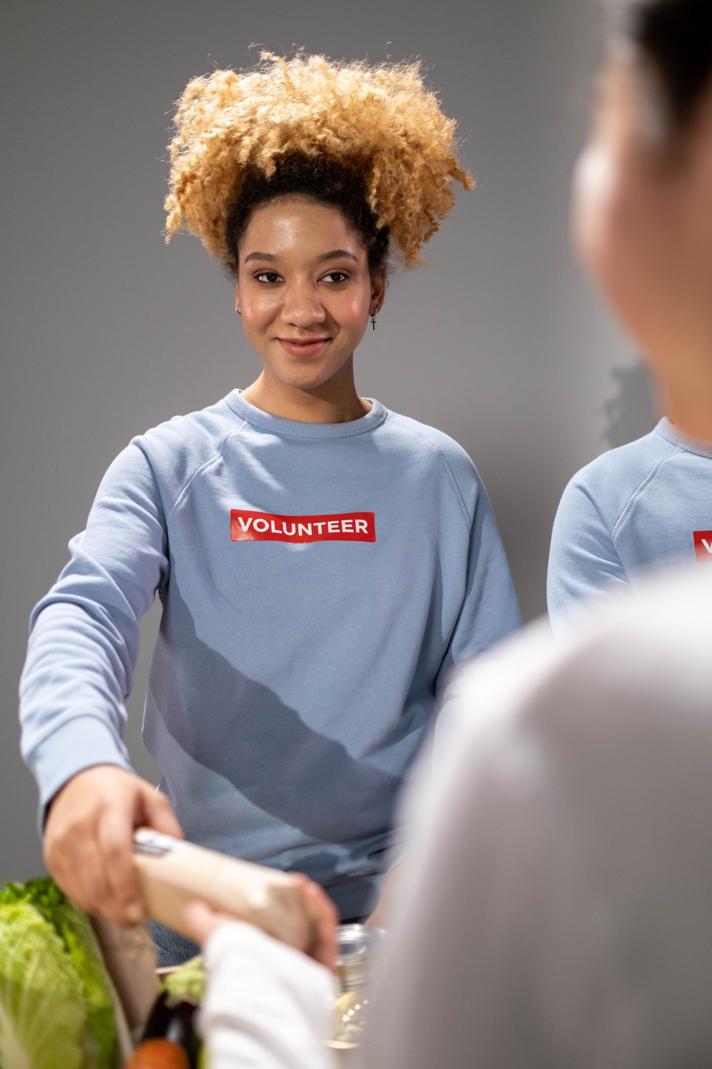 Volunteer helping distribute groceries to community members