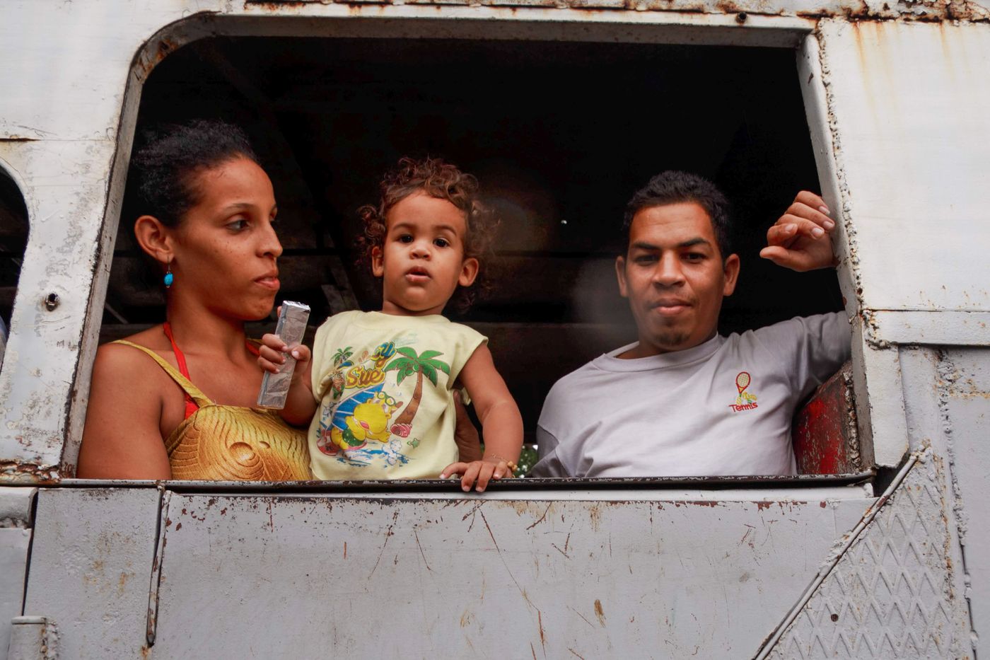 Family of three looking from the window of a passenger train