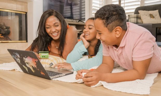 Happy family sharing a laptop at home